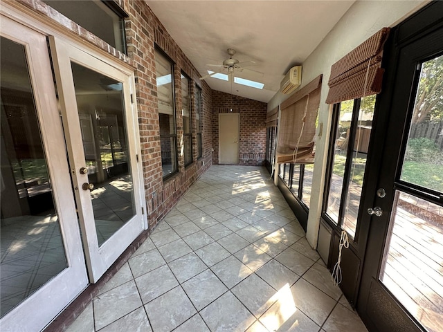 unfurnished sunroom featuring a wall mounted air conditioner, lofted ceiling with skylight, and ceiling fan