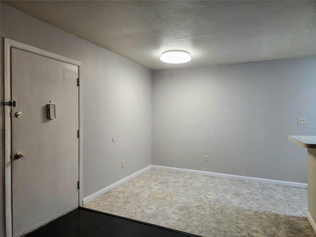 unfurnished room featuring a textured ceiling