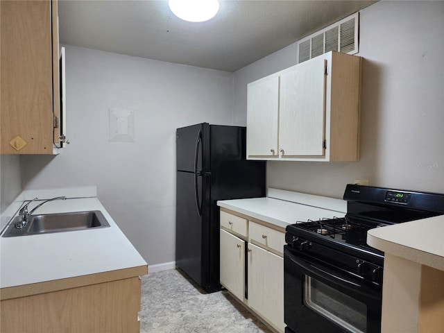 kitchen featuring visible vents, baseboards, a sink, black appliances, and light countertops