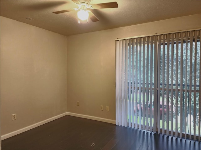 spare room featuring baseboards, a textured ceiling, wood finished floors, and a ceiling fan