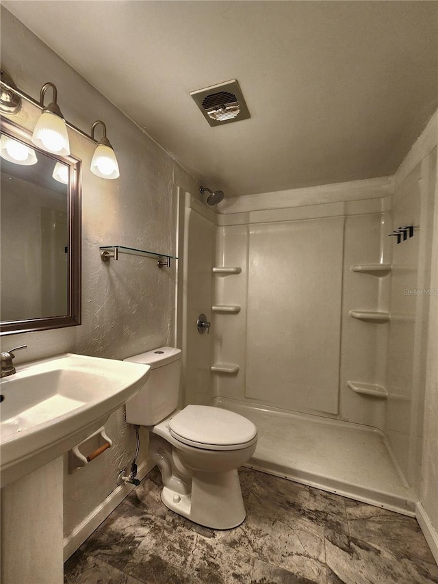 full bath with visible vents, toilet, baseboards, walk in shower, and a textured wall