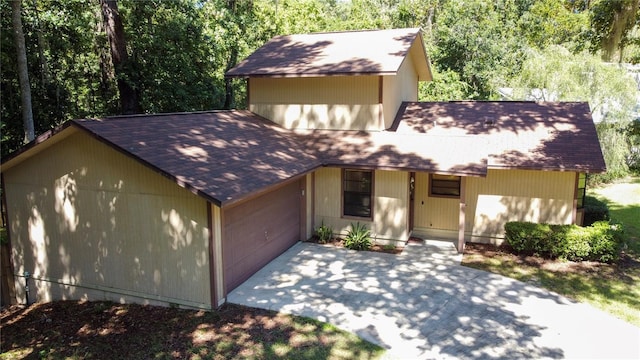 rustic home featuring driveway and an attached garage