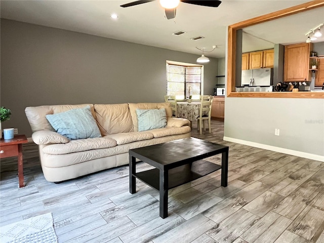 living area featuring ceiling fan, wood finished floors, and visible vents