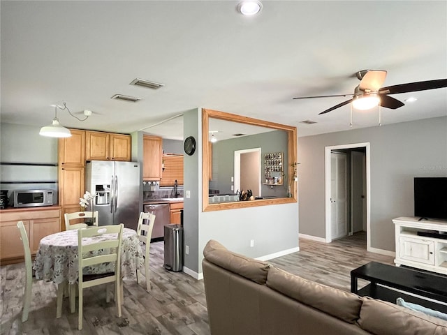 kitchen featuring stainless steel appliances, open floor plan, and visible vents