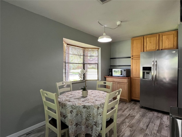 dining space with baseboards and light wood finished floors