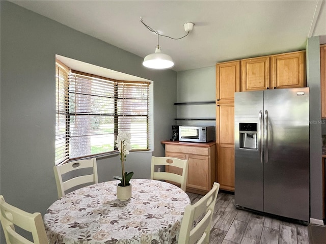 kitchen with light wood-style flooring, pendant lighting, and stainless steel appliances