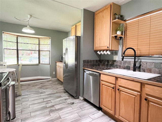 kitchen featuring appliances with stainless steel finishes, dark countertops, a sink, and wood tiled floor