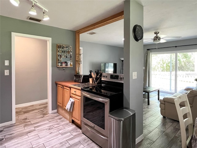 kitchen with wood finish floors, visible vents, and stainless steel electric stove