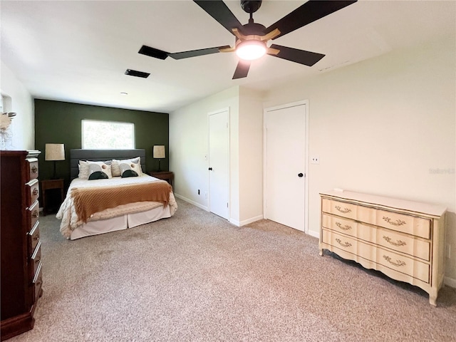 carpeted bedroom with ceiling fan and baseboards