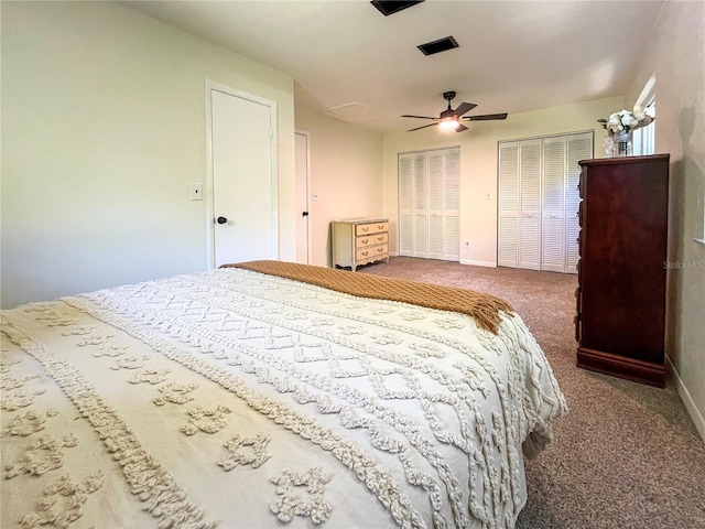 carpeted bedroom featuring ceiling fan, baseboards, and two closets