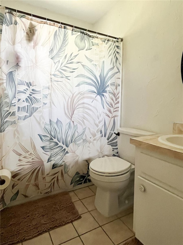 full bathroom with toilet, shower / bath combo, vanity, and tile patterned floors