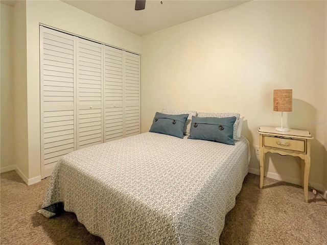 bedroom with a ceiling fan, baseboards, a closet, and carpet flooring