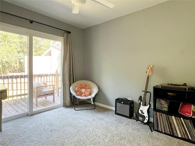 living area featuring carpet, baseboards, and ceiling fan