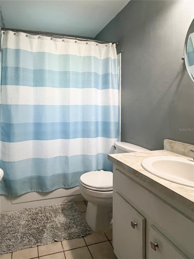 bathroom featuring toilet, curtained shower, tile patterned flooring, and vanity