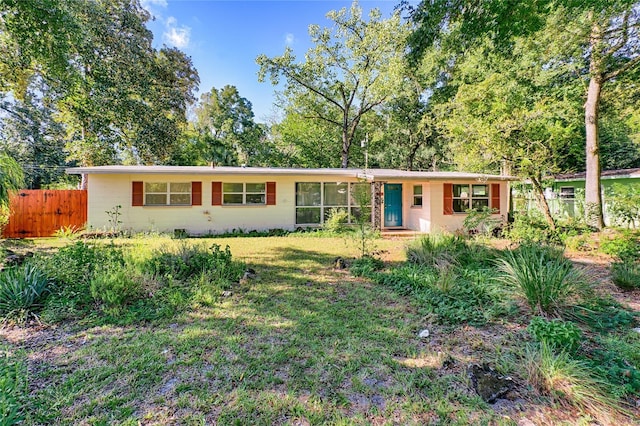 ranch-style house featuring a front yard and fence