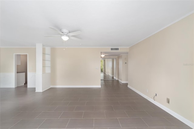 unfurnished room with ceiling fan, dark tile patterned floors, and ornamental molding