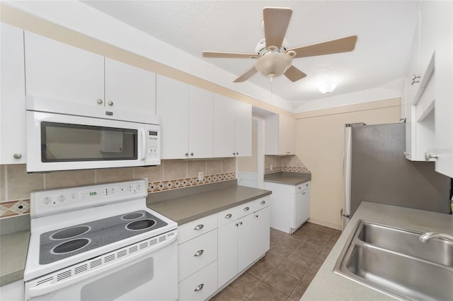 kitchen with sink, white appliances, white cabinetry, and backsplash