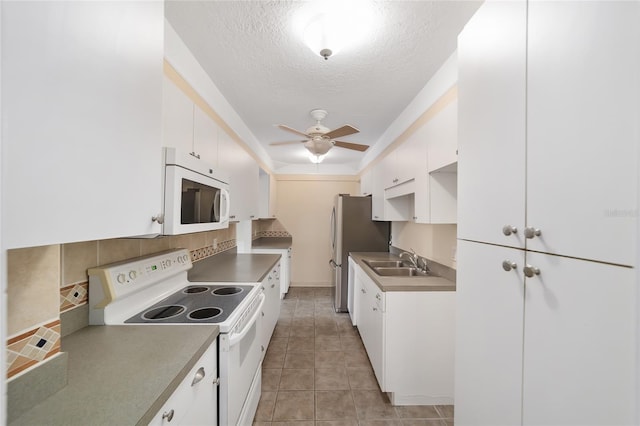 kitchen with sink, backsplash, a textured ceiling, white appliances, and white cabinets