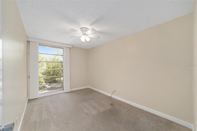 spare room with light carpet, ceiling fan, and a textured ceiling