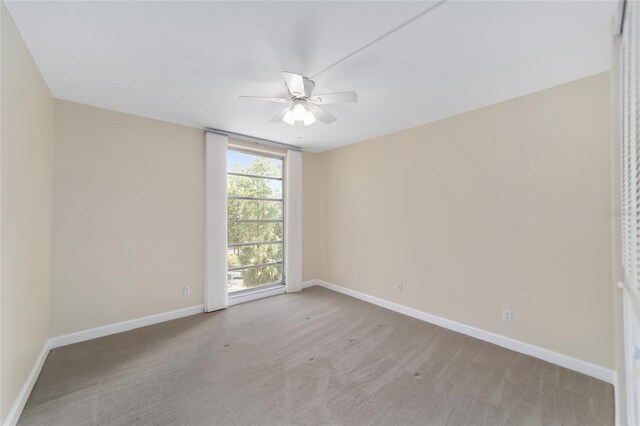 carpeted spare room featuring ceiling fan