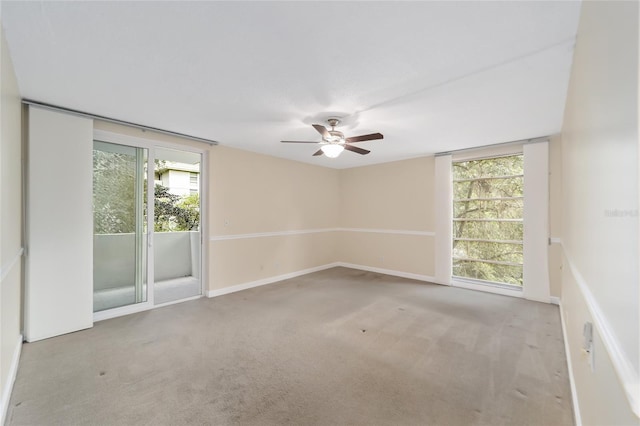 carpeted spare room with a wealth of natural light and ceiling fan