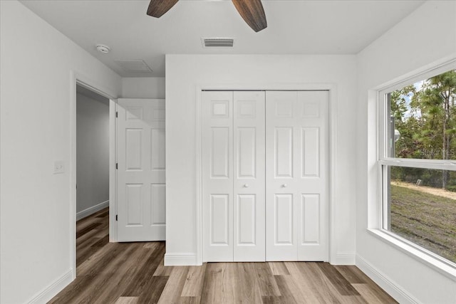 unfurnished bedroom featuring ceiling fan, a closet, and dark wood-type flooring