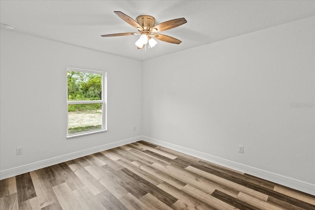 spare room with light wood-type flooring and ceiling fan