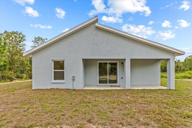 rear view of house featuring a patio and a lawn