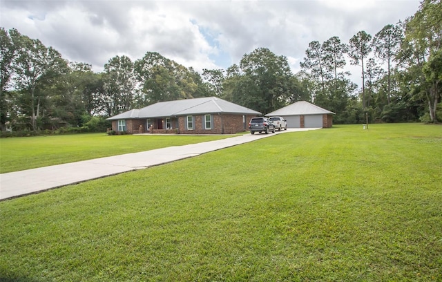 single story home featuring an outbuilding, a garage, and a front lawn