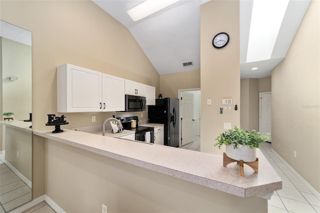 kitchen with visible vents, lofted ceiling with skylight, a peninsula, light countertops, and black appliances