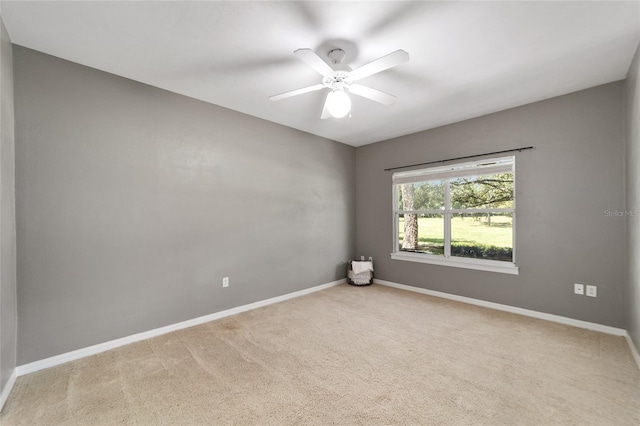 empty room with ceiling fan and light carpet