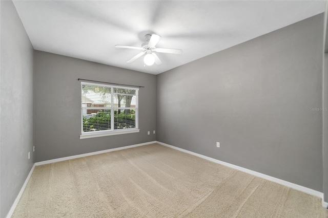 spare room with ceiling fan and light carpet