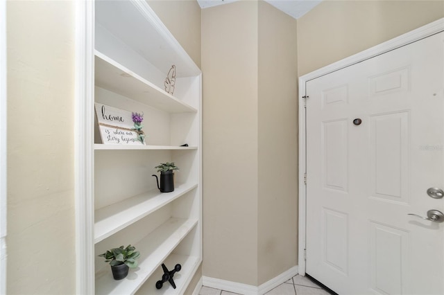 doorway to outside with baseboards and light tile patterned floors