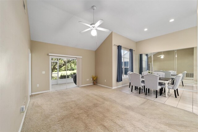 dining room with light carpet, ceiling fan, vaulted ceiling, and plenty of natural light