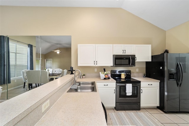 kitchen with electric stove, light tile patterned floors, sink, white cabinets, and black fridge