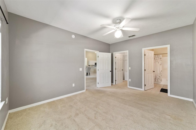 unfurnished bedroom featuring baseboards, a spacious closet, visible vents, and light colored carpet