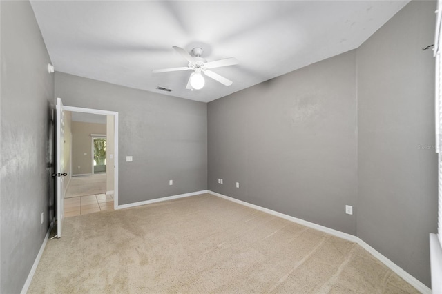 empty room with a ceiling fan, baseboards, visible vents, and carpet flooring