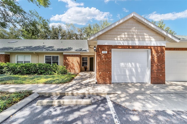 single story home with a garage, brick siding, driveway, and a shingled roof