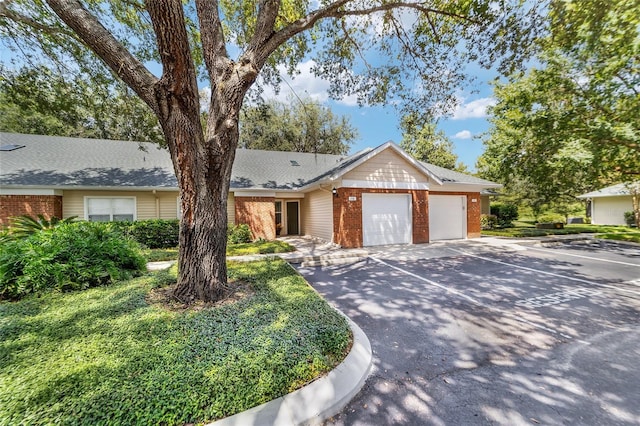 ranch-style house featuring an attached garage and brick siding