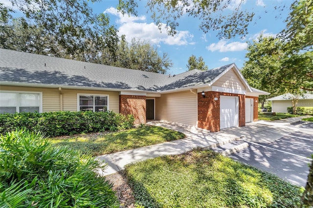 ranch-style house featuring a garage, concrete driveway, brick siding, and roof with shingles