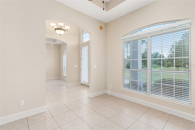 unfurnished room featuring light tile patterned floors and a notable chandelier