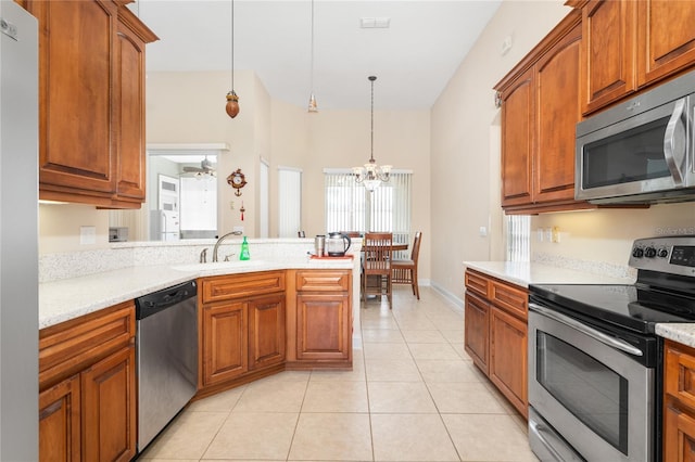 kitchen featuring ceiling fan with notable chandelier, light tile patterned floors, sink, hanging light fixtures, and appliances with stainless steel finishes