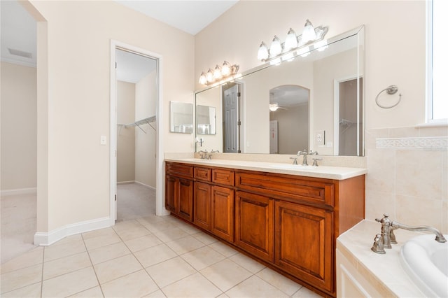 bathroom featuring tile patterned flooring, crown molding, a washtub, ceiling fan, and vanity