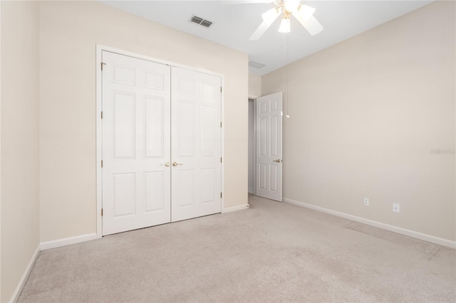 unfurnished bedroom with light colored carpet, ceiling fan, and a closet