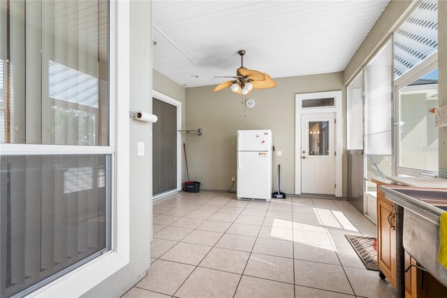 unfurnished sunroom featuring ceiling fan