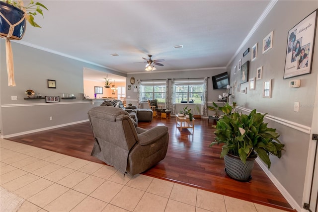 living room with ceiling fan, ornamental molding, and tile patterned floors