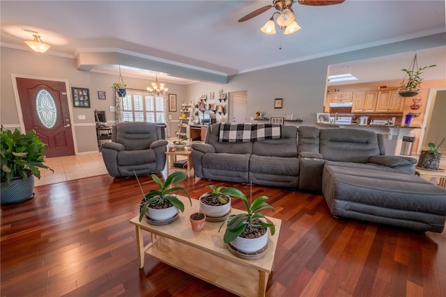 living room featuring ceiling fan with notable chandelier, tile patterned flooring, and ornamental molding