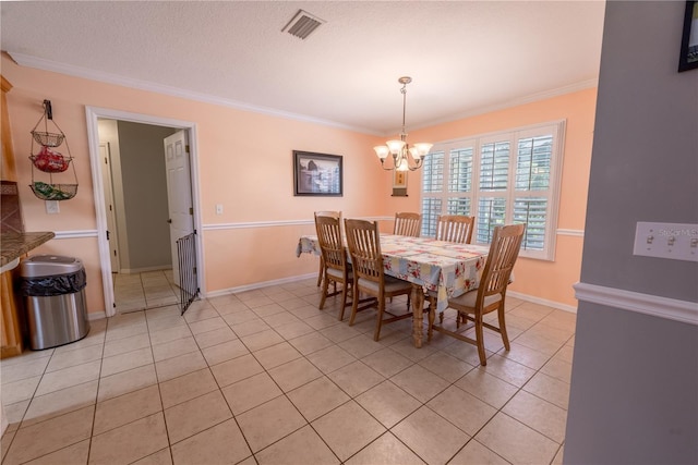 dining space with crown molding, a chandelier, and light tile patterned flooring