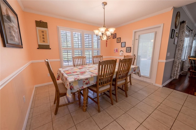 tiled dining space featuring a chandelier and ornamental molding