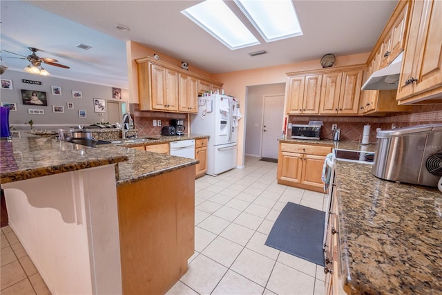 kitchen featuring white appliances, kitchen peninsula, decorative backsplash, a skylight, and ceiling fan